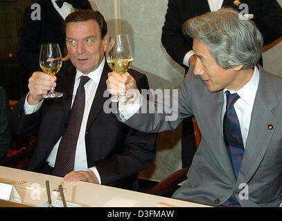 (dpa) - Japanese Prime Minister Junichiro Koizumi (R) and German Chancellor Gerhard Schroeder toast towards the other guests with a wine named 'Friendship' during dinner at a restaurant in Tokyo, Japan, Thursday 9 December 2004. Schroeder is in Tokyo for a three-day visit. Stock Photo