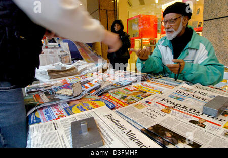(dpa) -  A newspaper salesman handles change at his newsstand in front of a department store at the famous Zeil shopping street in Frankfurt, Germany, 6 November 2004. Stock Photo