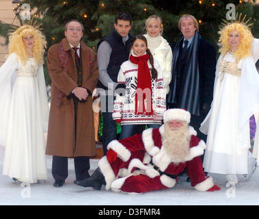 (dpa) - The cast of the German Christmas TV movie 'Hilfe, meine Tochter heiratet' (help, my daughter is getting married) pose for the photographers with two angels and a Santa Claus at the Taschenbergpalais in Dresden, Germany, 6 December 2004. Pictured are (L-R) Jaecki Schwarz, Luca Zamperoni, Arzu Bazmann, Saskia Valencia and Ulrich Pleitgen. Stock Photo