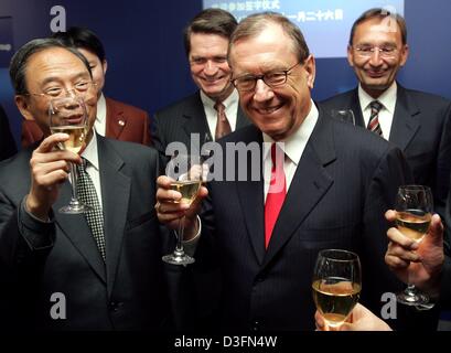 (dpa) - DaimlerChrysler Chairman Juergen Schrempp (front R) clinks glasses with Chinese Premier Minister Zeng Peiyan (L) while Rolf Bartke (C rear), head of the Mercedes-Benz worldwide vans unit, and Harald Hauke (R), President for the transporter production in China, look on in Bremen, Germany, Friday 26 November 2004. The event took place on the occasion of the ceremony for two s Stock Photo