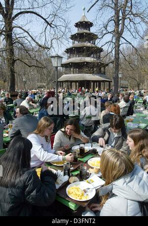 (dpa) - Guests enjoy a meal and a beer on a warm spring day in the Beer Garden at the Chinese Tower in the English Garden in Munich, 25 March 2003. Temperatures of around 20 degree Celsius are forecast to continue during the next days. Stock Photo