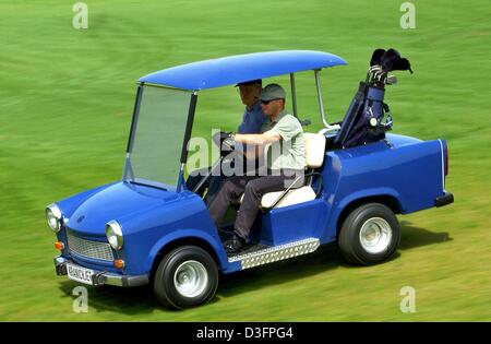 (dpa) - Two golfers drive from one hole to the next with an adapted Trabant in Vorbeck, Germany, 8 May 2003. The little east German Trabant automobile nicknamed 'Trabi' of the former GDR (German Democrtic Republic) is still a favorite with car collectors and car fans. This exemplar is the only Trabant that has been reconstructed into a golf cart. Usually Mecedes, Chevrolet and othe Stock Photo