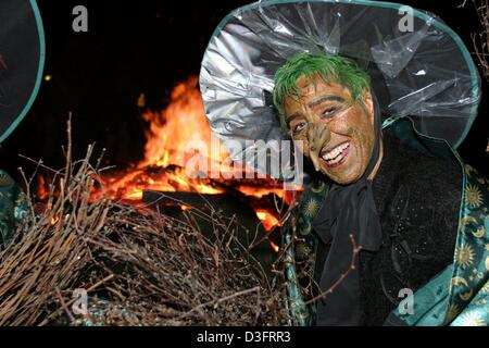 (dpa) - A woman dressed up as witch poses in front of the fire celebrating Walpurgis Night in Schierke in the Harz Mountains, eastern Germany, 30 April 2003. Walpurgis Night is an old pagan festival, which borrowed its name from Saint Walburga whose feast occurs on May Day. On this night witches are believed to ride on broomsticks and he-goats to places of old pagan sacrifices in t Stock Photo