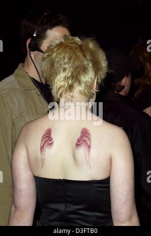 (dpa) - Kelly Osbourne, daughter of ex-shockrocker Ozzy Osbourne, arrives at the MTV show Icon - Metallica at the Universal Studios - in Los Angeles, California, 03 May 2003. After having changed her hair colour into blond although this is not trendy anymore, she now has a daring temporary tattoo showing angel's wings on her back. Stock Photo