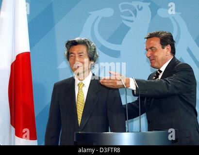 (dpa) - German Chancellor Gerhard Schroeder (R) makes a welcoming gesture towards Japanese Prime Minister Junichiro Koizumi in the Chancellery in Berlin, 30 April 2003. After the meeting Schroeder stated his interest in normalising the relationships with the USA. Koizumi had expressed his expectations that the disagreement on the Iraq War between Germany and the United States will  Stock Photo