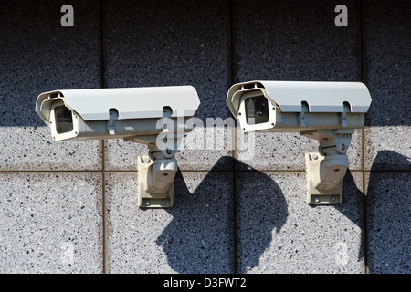 two white security cameras on the concrete wall Stock Photo