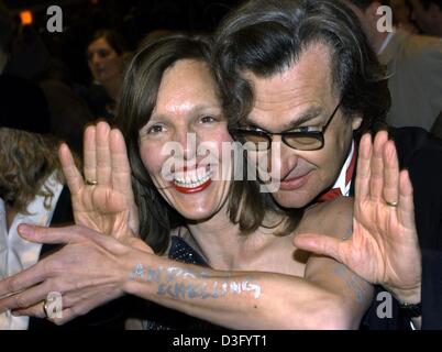 (dpa) - German film director Wim Wenders uses his hands as a viewfinder as he chats with his wife Donata Schmidt during the opening of the 53rd annual Berlin film festival in Berlin, 6 February 2003. Schmidt has 'Andrea Schelling' written on her arm, the name of her favorite fashion designer. More than 2,000 guests attended the opening ceremony of the Berlinale, which is after Cann Stock Photo