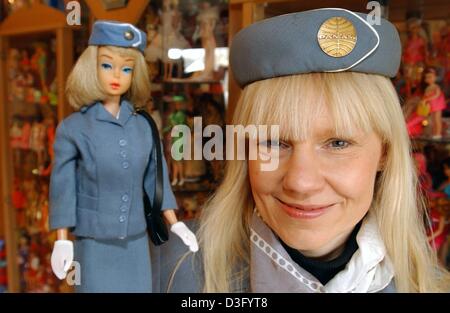 (dpa) - Barbie doll 'doctor' Bettina Dorfmann, dressed as a flight attendant to match the Barbie's costume, poses with one of her favorite 'resuscitated' Barbies in Duesseldorf, Germany, 30 January 2003.  Dorfmann turned her hobby of repairing damaged Barbie dolls into a full-time job; she restores beauty to approximately 15 Barbies from Germany, Belgium, and Holland per week.  Acc Stock Photo