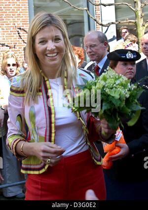 (dpa) - The Dutch crown princess Maxima with flowers in her hand smiles towards the photographers as she and her husband crown prince Willem-Alexander visit the city of Wassennaar 16 April 2003. The couple unveiled a statue depicting a couple dancing tango. Stock Photo