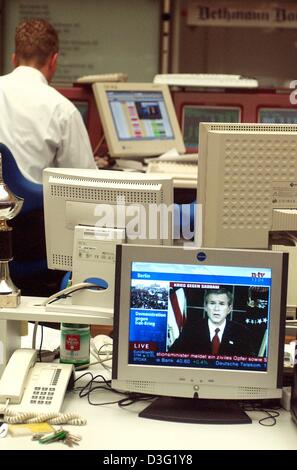(dpa) - A stock broker sits in front of his computer terminal while behind him broadcasts the German news broadcaster n-tv a newsreel of the latest speach of US-President Bush at the stock exchange in Frankfurt, Germany, 20 March 2003. The stock market trade has turned into a low key nervous haggling since the start of the war with Iraq. The expected uplift of the market prices did