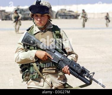 (dpa) - A US marine of the 3rd Infantry Battalion holds an assault rifle in Camp Coyote in Kuwait, Asia, 15 March 2003. More than 150,000 US and British soldiers are presently based in Kuwait's northern desert. According to the US Department of Defense, these soldiers are prepared to launch an attack on Iraq. Stock Photo