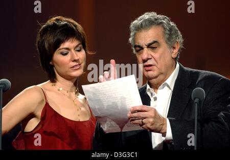 (dpa) - Spanish tenor Placido Domingo stands with Norwegian soprano Sissel Kyrkjebo on stage and reads a note with musical instructions during the general rehearsal for the Jose Carreras charity gala concert in Leipzig, Germany, 19 December 2002. The charity gala was in aid of cancer research and treatment. Placido Domingo's family emigrated in 1949 to Mexico where he grew up and s Stock Photo