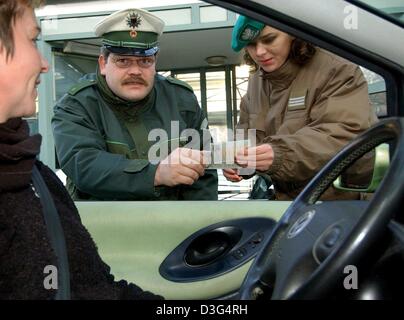 (dpa) - German and Polish border control officers together check the papers of a traveller at the Polish-German border crossing at the Stadtbruecke (city bridge) in Frankfurt Oder, eastern Germany, 11 December 2003. Usually, travellers have to show their papers twice when crossing the border. The aim of the joint border controls at the checkpoints in Frankfurt Oder and Kuestrin-Kie Stock Photo