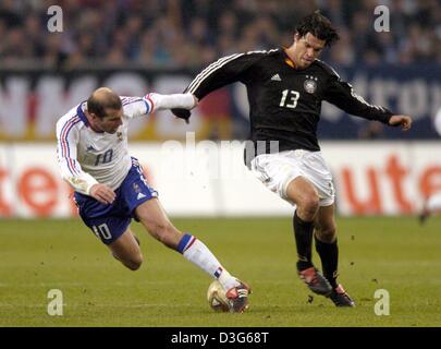 (dpa) - French midfielder star and team captain Zinedine Zidane (L) and German midfielder Michael Ballack (R) fight for the ball during the international soccer game opposing Germany and France, in Gelsenkirchen, Germany, 15 November 2003. France won the match 3-0. Stock Photo