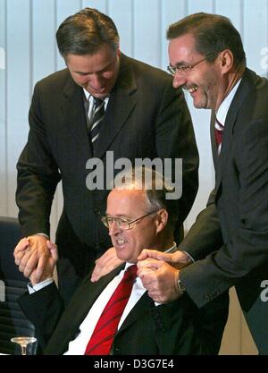 (dpa) - German Finance Minister Hans Eichel (C) shakes hands with Matthias Platzek (R), the Prime Minister of the state of Brandenburg, and Berlin's Mayor Klaus Wowereit ahead of the Chairmanship meeting of the social democratic SPD party in Berlin, 10 November 2003. Eichel rejected the request of the two leaders of the eastern German states of Brandenburg and Berlin to compensate  Stock Photo