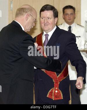 (dpa) - German Defence Minister Peter Struck awards the German Federal Cross of Merit to the outgoing NATO Secretary General George Robertson for his support of the Federal Republic of Germany in the NATO and his contribution to the German-American friendship in Berlin, Germany, 3 November 2003. Stock Photo