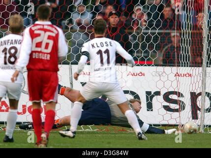 (dpa) - Bayern's goalkeeper Oliver Kahn (below) stretches and saves the penalty kick of Kaiserslautern's forward Miroslav Klose (no. 11) during the Bundesliga soccer game of FC Bayern Munich against FC Kaiserslautern in Munich, 25 October 2003. Kaiserslautern's Markus Anfang (no. 18) and Bayern's midfielder Sebastian Deisler (2nd from L) are watching the scene. Bayern won the tenth Stock Photo