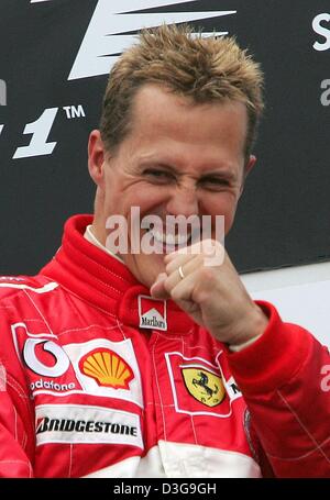 (dpa) - German Ferrari Formula One driver Michael Schumacher celebrates on the podium after the Belgian Formula One Grand Prix in Spa, 29 August 2004. Michael Schumacher finished in second place in the Grand Prix, clinching an unprecedented seventh world championship title despite not winning for just the second time in 14 races this season. Stock Photo