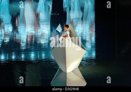 (dpa) - A little boy waving a greek flag crosses a lake in the Olympic Stadium with a little boat at the beginning of the opening ceremony of the Olympic Games in Athens, Friday 13 August 2004. He repreasents the close relation of all Greeks to the sea. Stock Photo
