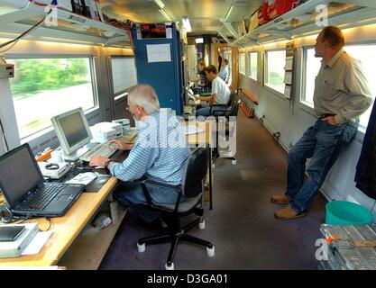 (dpa) - Mechanics work in a specially equipped ICE-S highspeed train of the Deutsche Bahn which runs at an average speed of 230 kmph along the new highspeed track between Hamburg and Berlin, near Ludwigslust, Germany, 30 September 2004. In test runs between the two biggest German cities the train records and measures data of the tracks and overhead contact lines. The new railway li Stock Photo