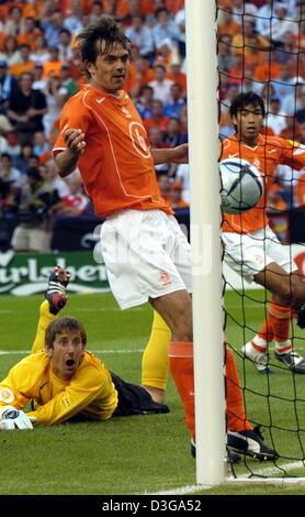 (dpa) - With horror Dutch goalkeeper Edwin van der Sar looks after the ball, just like his teammates Philip Cocu (front) and Giovanni van Brockhorst (rear), after a free kick during the Soccer Euro 2004 group game between Germany and the Netherlands in Porto, Portugal, 15 June 2004. The game ended in a 1-1 draw. +++NO MOBILE APPLICATIONS +++ Stock Photo