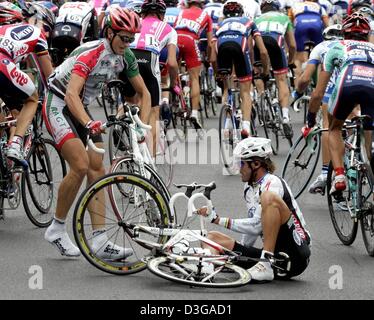 (dpa) - Italian cyclist Mario Cipollini (R) of team Domina Vacanze tries to get up after crashing with French Guillaume Auger (L) during the first stage of the Tour de France, near Liege, Belgium, 4 July 2004 near Liege. The first and 202.5km long stage of the 91st Tour de France cycling race took the cyclists from Liege to Charleroi. Stock Photo