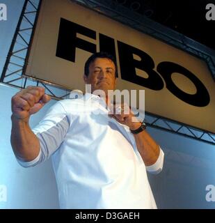 (dpa) - US actor Sylvester Stallone poses in a fighting position as he presents the products of his new fitness and health company Instone at the FIBO sport fair in Essen, Germany, 24 April 2004. The Hollywood star said he considered making a fourth 'Rambo' movie. Stallone was quoted as saying at the fair that he felt a little too old to play Rocky, but he would like to make anothe Stock Photo