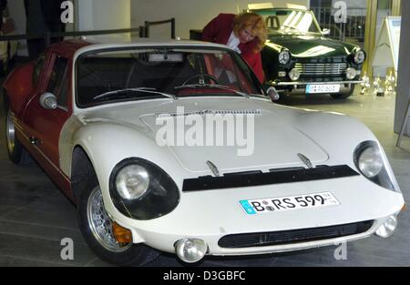 (dpa) - A woman looks at a Melkus RS 1000, a sports car which was built in the GDR (East Germany) in 1976, on display in the exhibition 'Die bunte Autowelt der DDR' (the colourful car world of the GDR), in Berlin, 8 November 2004. The sports car manufactured in Dresden has 90 hp. The exhibition runs until 14 January. Stock Photo