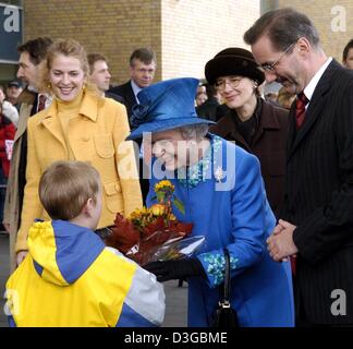 (dpa) - Her Majesty the Queen is welcomed with a flower bouquet by elementary school student Leo Evers after arriving from Berlin at the main station in Potsdam, Germany, 3 November 2004. Standing next to her is German state of Brandenburg Prime Minister Matthias Platzeck (R) and his compagnion Jeanette Jesorka. The Queen and her husband Prince Philip Duke of Edinbourgh visit the G Stock Photo