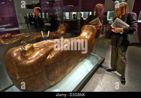 (dpa) - A visitor admires a golden 18th dynasty sarcophagus from the grave of  Juja and Tuja at the Art and Exhibition Hall in Bonn, Germany, 3 November 2004. The exhibition 'Tutankhamun - The Golden Beyond. Treasures from the Valley of the Kings' takes place in the former German capital of Bonn from 4 November 2004 until 1 May 2005. Stock Photo