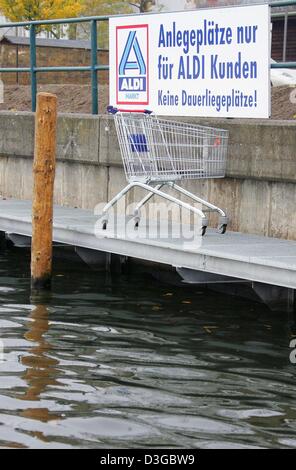 (dpa) - A trolley stands on a landing-stage featuring the sign 'Anlegeplaetze nur fuer ALDI Kunden. Keine Dauerliegeplaetze!' (Landing places only for ALDI clients. No permanent berths!) in Potsdam, Germany, 29 October 2004. This Potsdam Aldi store is located on one of the most sought-after places on the bank of the 'Tiefer See' (deep lake) with a view of the castle park Babelsberg Stock Photo