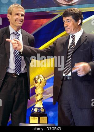 (dpa) - German national soccer team head coach Juergen Klinsmann (L) and the head coach of the Greek national soccer team, Otto Rehhagel, stand next to the 2005 FIFA Confederations Cup trophy after the competition draw at the Alte Oper in Frankfurt, Germany, 1 November 2004. The eight-nation-tournament will take place in Germany from 15 June until 29 June 2005 as a tune up for the  Stock Photo