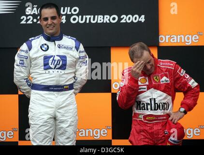 (dpa) - Colombian Formula One driver Juan Pablo Montoya (L) of BMW-Williams stands on the podium with third placed Brazilian Rubens Barrichello (Ferrari) after winning the Brazilian Formula One Grand Prix at the Interlagos circuit in Sao Paulo, Brazil, 24 October 2004. Stock Photo