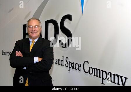 (dpa) - Rainer Hertrich, one of the two current CEOs of the European Aeronautic Defence and Space Company (EADS), poses in front of the corporate logo at the company's headquarters in Ottobrunn, near Munich, Germany, 7 October 2004. Stock Photo