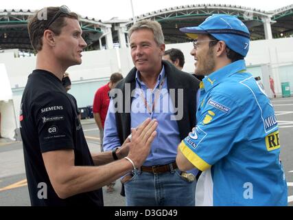 (dpa) - Canadian formula one driver Jacques Villeneuve (R, Renault), his British manager Craig Pollock and the Scot David Coulthard (L, McLaren Mercedes) talk on the racing circuit in Suzuka, Japan, 7 October 2004. The Japanese formula one Grand Prix will be underway on Sunday, 10 October 2004. Stock Photo