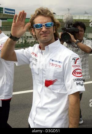 (dpa) - Italian formula one pilot Jarno Trulli (Toyota) waves to his fans on the racing circuit in Suzuka, Japan, 7 October 2004. The Japanese formula one Grand Prix which will be underway on Sunday, 10 October 2004, is Trulli's first race for his new team. Stock Photo