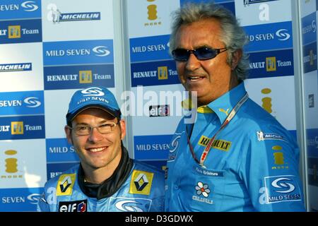 (dpa) - Canadian formula one pilot Jacques Villeneuve (L) and his Renault team leader Flavio Briatore (R) pose on the new formula one racing circuit in Shanghai, China, Thursday, 23 September 2004. Ex-world champion Villeneuve in the next three races will replace Jarno Trulli who signed with Toyota. In the upcoming season Villeneuve will be a regular driver with the Swiss Sauber te Stock Photo