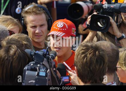 (dpa) - Seven-time formula one world champion Michael Schumacher (Ferrari) is in the centre of media attention as he arrives in the paddocks of the racing circuit in Monza, Italy, Thursday, 9 September 2004. The Grand Prix of Italy will be underway in Monza on Sunday.