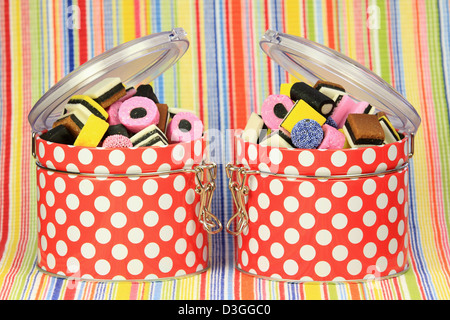 Liquorice sweets in colourful containers against a colourful background. Stock Photo
