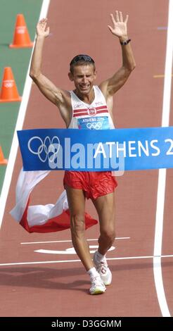 (dpa) Robert Korzeniowski from Poland crosses the finish line of the men's 50 km walk in the Olympic stadium at the Athens 2004 Olympic Games. Stock Photo