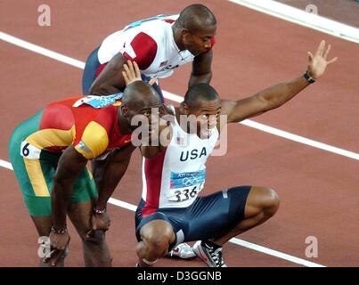 (dpa) - US sprinter Bernhard Williams (squatting) smiles and reacts after taking bronze in the men's 200m final at the Athens 2004 Olympic Games, Thursday 26 August 2004. Portugal's Francis Obikwelu (L) and winner Shawn Crawford from the US (C) join him. Stock Photo