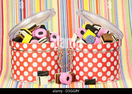 Liquorice sweets in colourful containers against a colourful background. Stock Photo