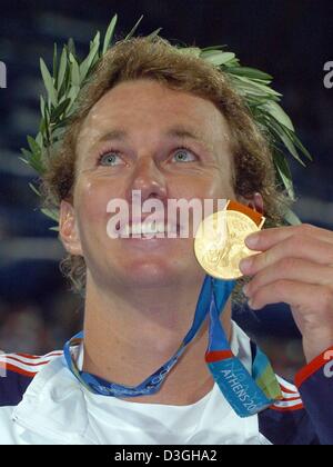 (dpa) - Aaron Peirsol from the USA shows his gold medal after winning the men's 200m backstroke final at the Olympic Aquatic Centre in Athens, Thursday 19 August 2004. Peirsol had earlier been disqualified and later requalified after a supposed wrong turn. Stock Photo