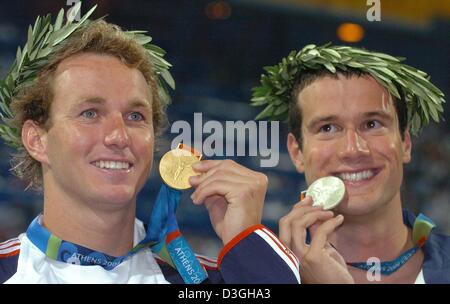 (dpa) - (from L:) Aaron Peirsol from the USA shows his gold medal next to silver medalist Markus Rogan from Austria at the medal ceremony of the men's 200m backstroke at the Olympic Aquatic Centre in Athens, Thursday 19 August 2004. Peirsol had earlier been disqualified and later requalified after a supposed wrong turn. Stock Photo