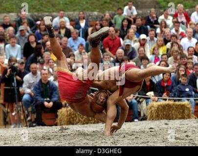 (dpa) - Two actors, dressed as gladiators, stage a fight in the historic ruins of the amphitheatre in Trier, Germany, 14 August 2004. At the Roman spectacle 'bread and games' visitors relive what life was like in Roman times 2000 years ago. Stock Photo