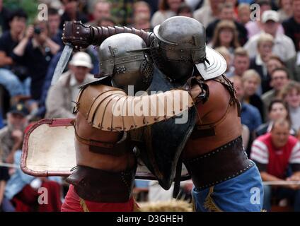 (dpa) - Two actors, dressed as gladiators, stage a fight in the historic ruins of the amphitheatre in Trier, Germany, 14 August 2004. At the Roman spectacle 'bread and games' visitors relive what life was like in Roman times 2000 years ago. Stock Photo