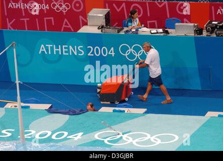 (dpa) - A helper hoovers the flower between the training sessions of the gymnasts at the Oaka Hall in Athens, Greece, 09 August 2004. The 2004 Olympics will be launched with the Opening Ceremony on 13 August. Stock Photo