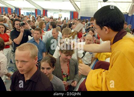 (dpa) -  Karmapa Thaye Dorje (R), a  monk from Tibet, blesses participants during the inaugural ceremony of a buddhist summer camp in Immenhausen, Germany, Thursday 29 July 2004. Several thousand Buddhists are participating in the inauguration of the summer camp which introduces and advises visitors in the foundations of meditative practice and Buddhist teachings. Stock Photo