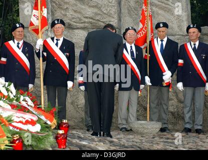 (dpa) - German Chancellor Gerhard Schroeder (front) bows in front of Polish veterans in front of the memorial which commemorates the resistance fighters and people killed in the Warsaw Uprising, in Warsaw, Poland, 01 August 2004. Schroeder was among the international guests who participated in the celebrations commemorating the 60th anniversary of the Warsaw Uprising. Stock Photo