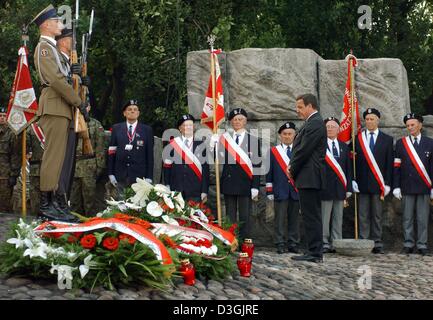 (dpa) - German Chancellor Gerhard Schroeder pauses for a moment as he stands in front of the memorial which commemorates the resistance fighters and people killed in the Warsaw Uprising, in Warsaw, Poland, 01 August 2004. Schroeder was among the international guests who participated in the celebrations commemorating the 60th anniversary of the Warsaw Uprising. Stock Photo